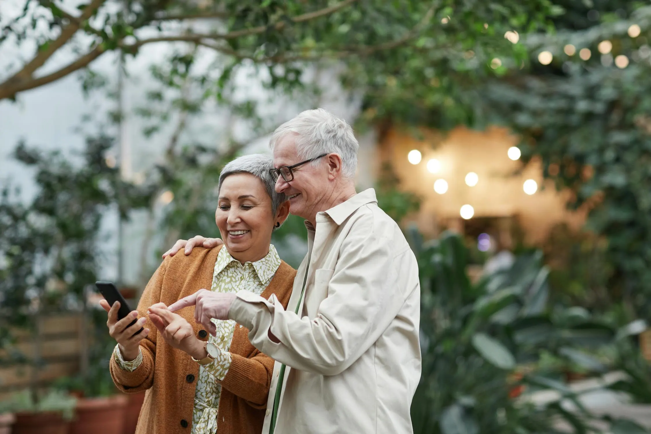 An adult daughter helps her mother get comfortable with a new smartphone