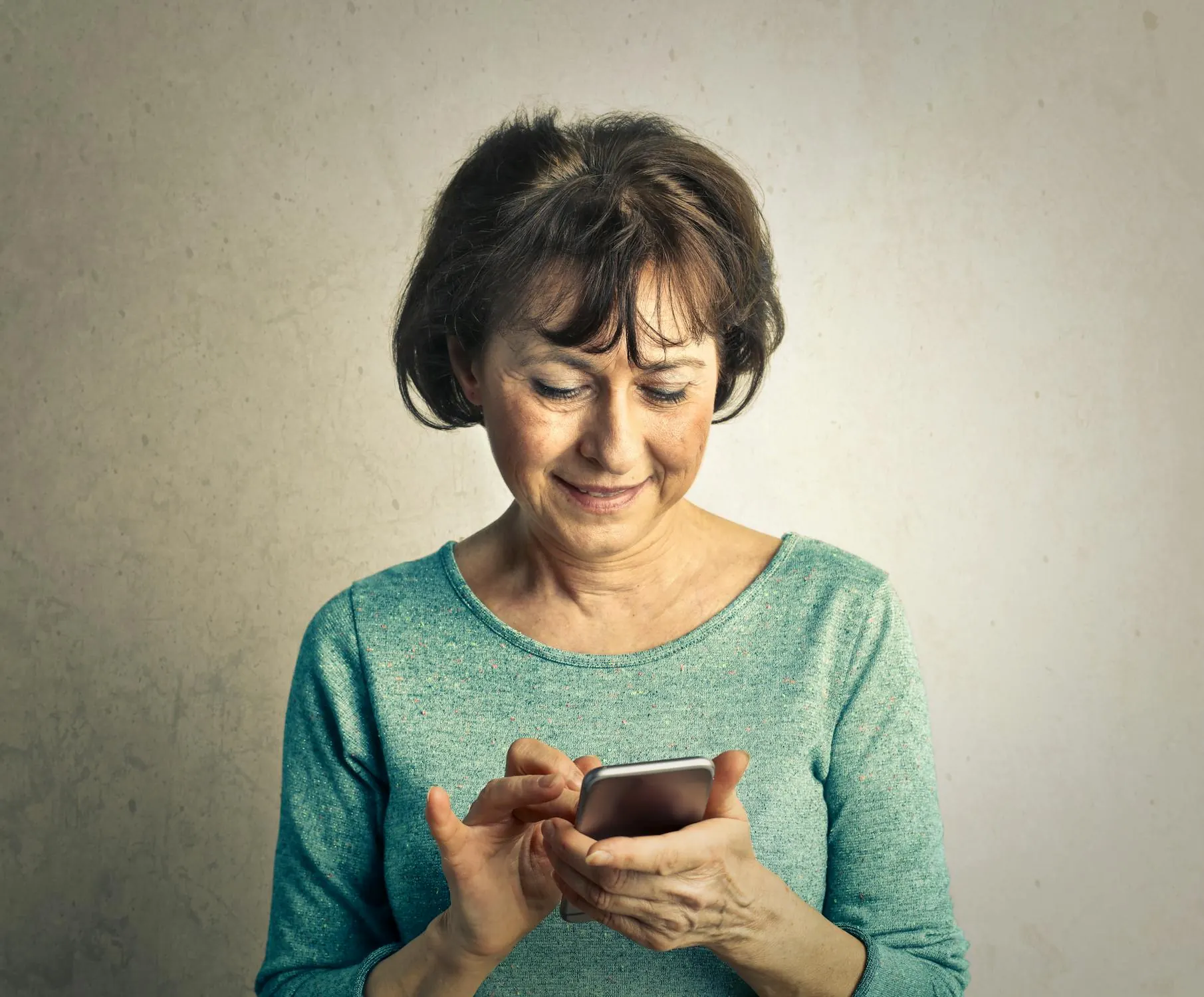 A senior woman using a simplified smartphone home screen